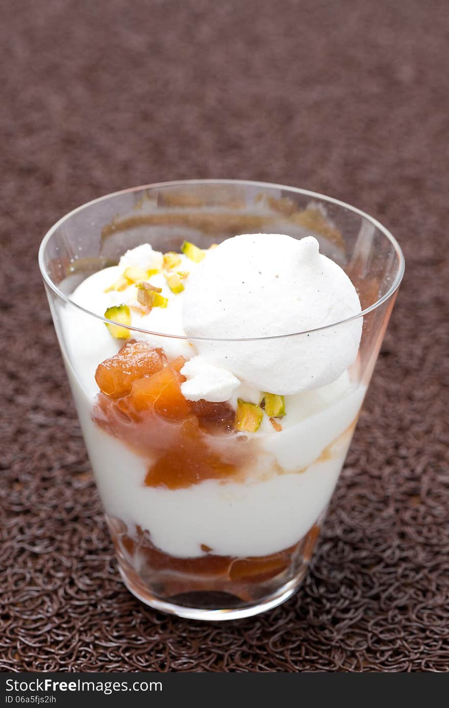 Dessert with peaches, whipped cream, meringue and pistachios