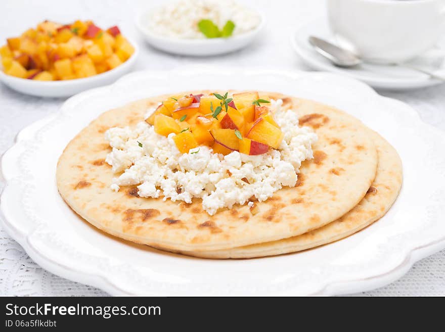 Flat bread with cottage cheese with honey, nuts, fresh peaches and thyme, close-up, horizontal