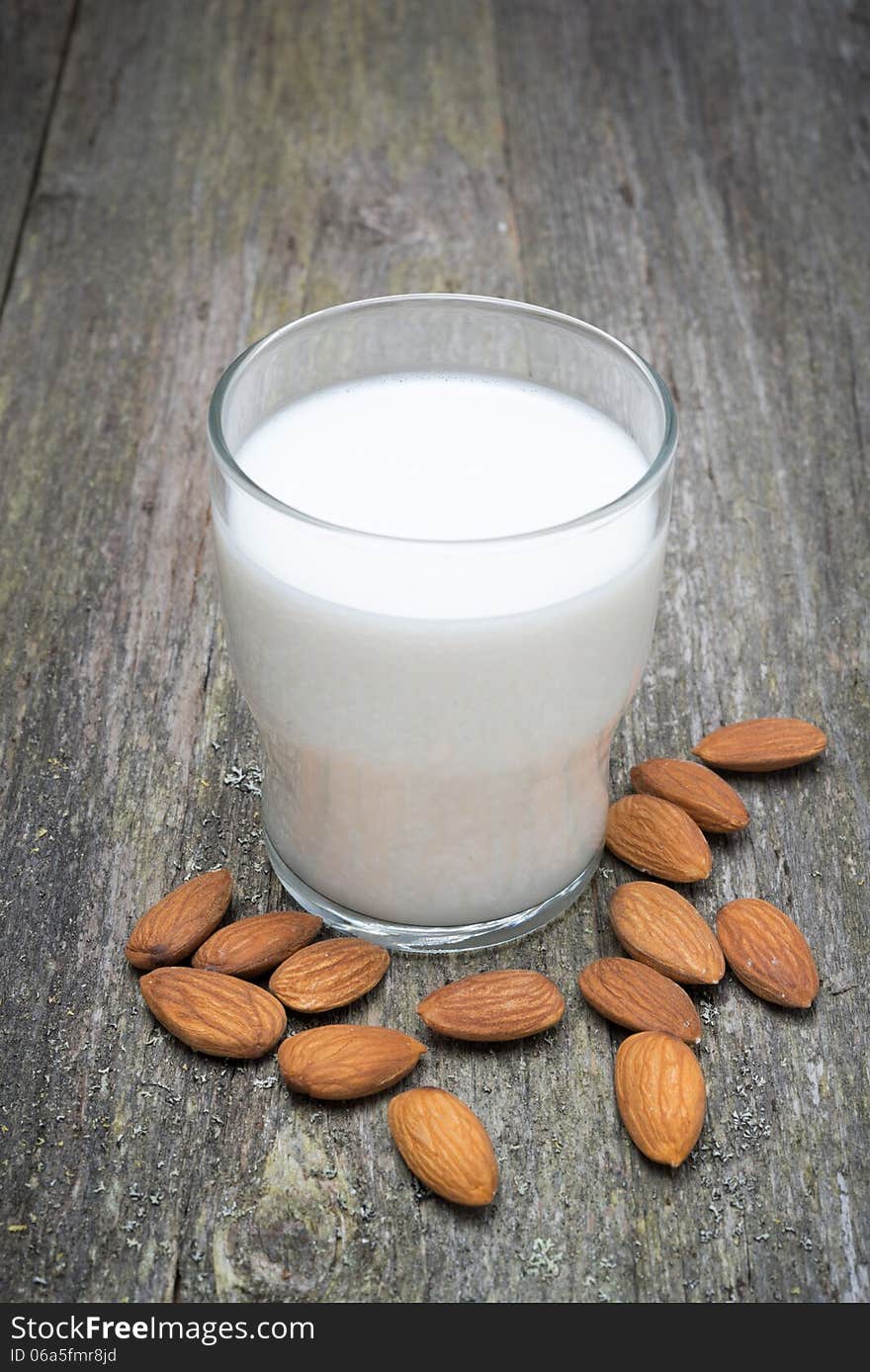 Glass of almond milk on a wooden table