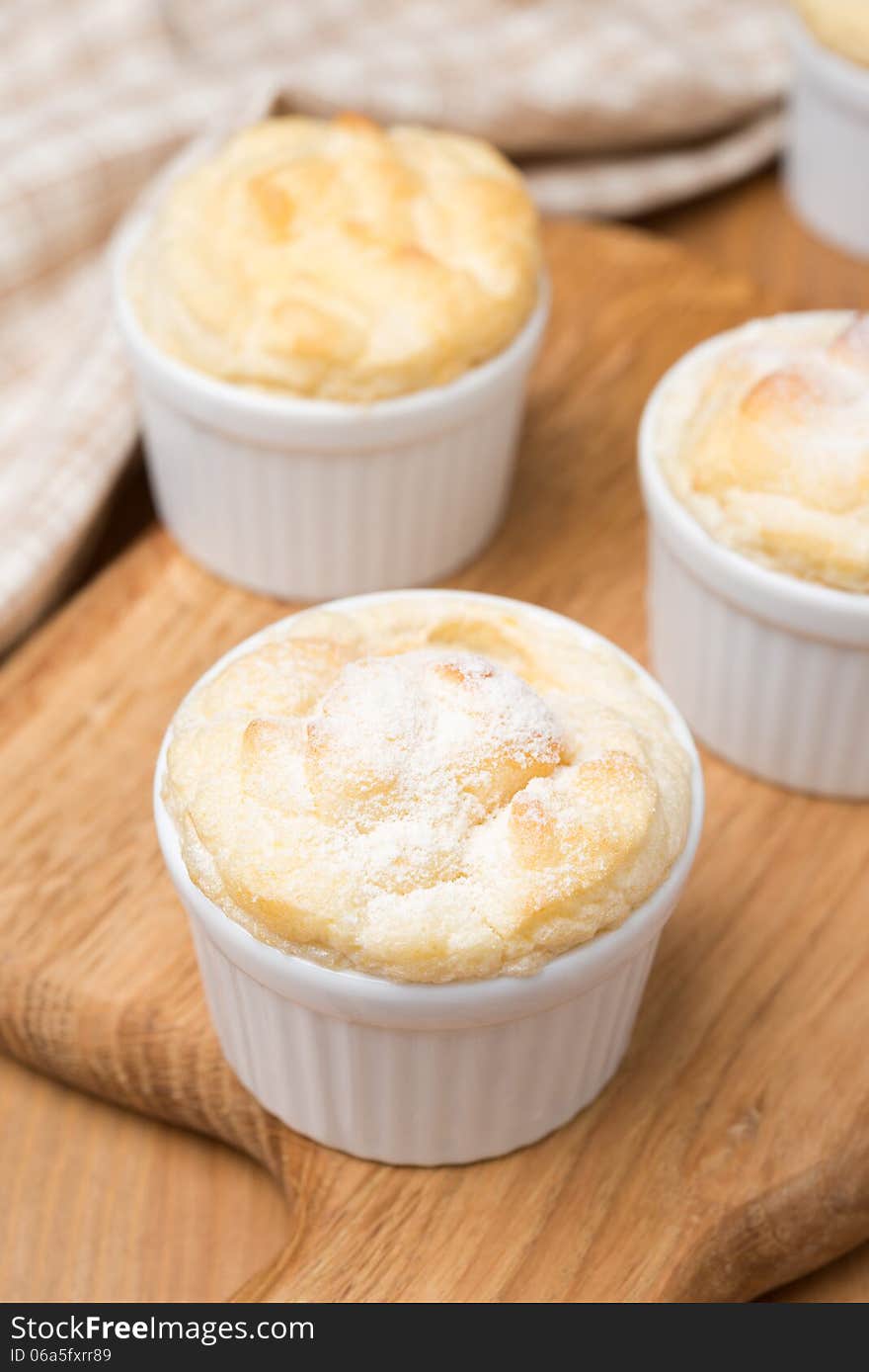 Peach souffle in the portioned form on a wooden board, vertical close-up