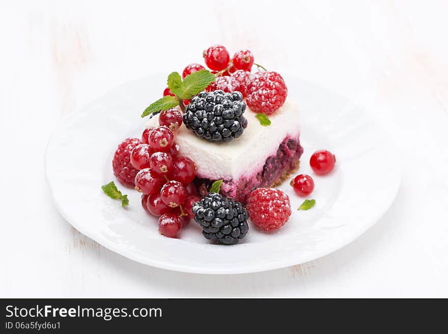 Piece of cake with fresh berries on the plate, close-up