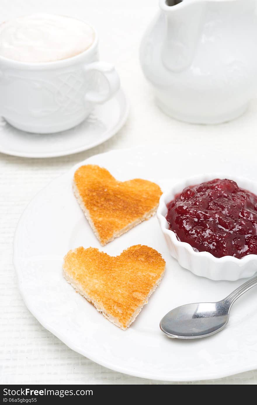 Toasted bread in the shape of heart with berry jam and coffee