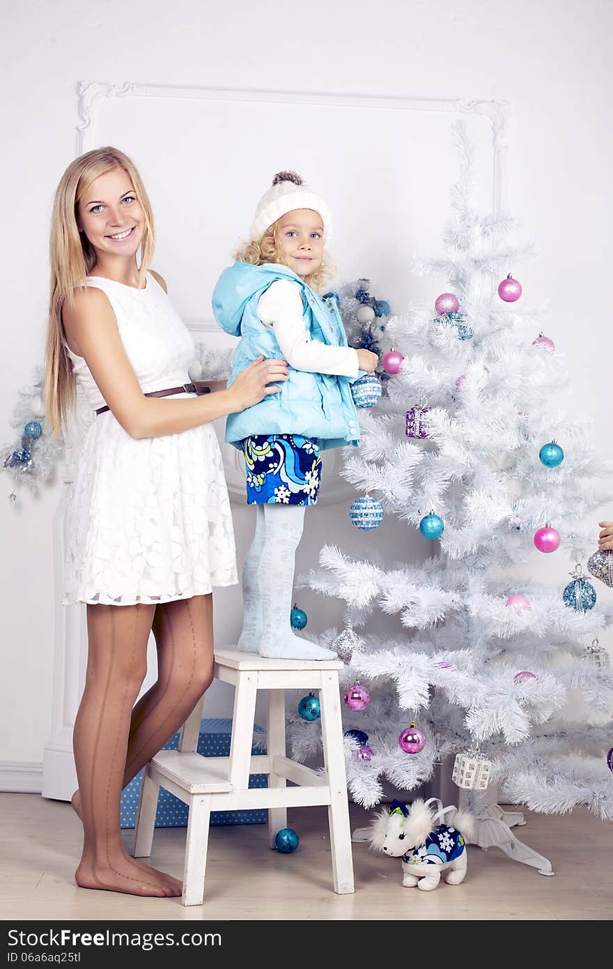 Little girl and her mother decorate Christmas tree. Little girl and her mother decorate Christmas tree