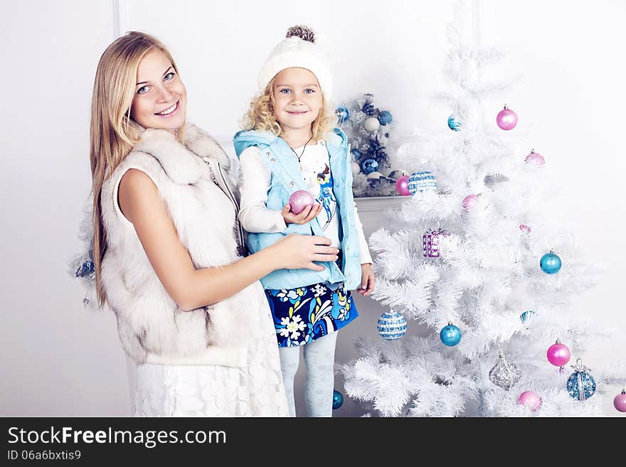 Little girl and her mother decorate Christmas tree. Little girl and her mother decorate Christmas tree