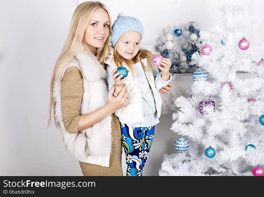 Little girl and her mother decorate Christmas tree. Little girl and her mother decorate Christmas tree