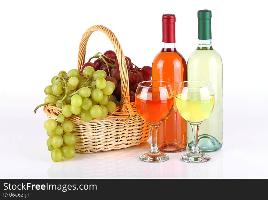 Bottles of wine with basket full of grapes on white background. Bottles of wine with basket full of grapes on white background