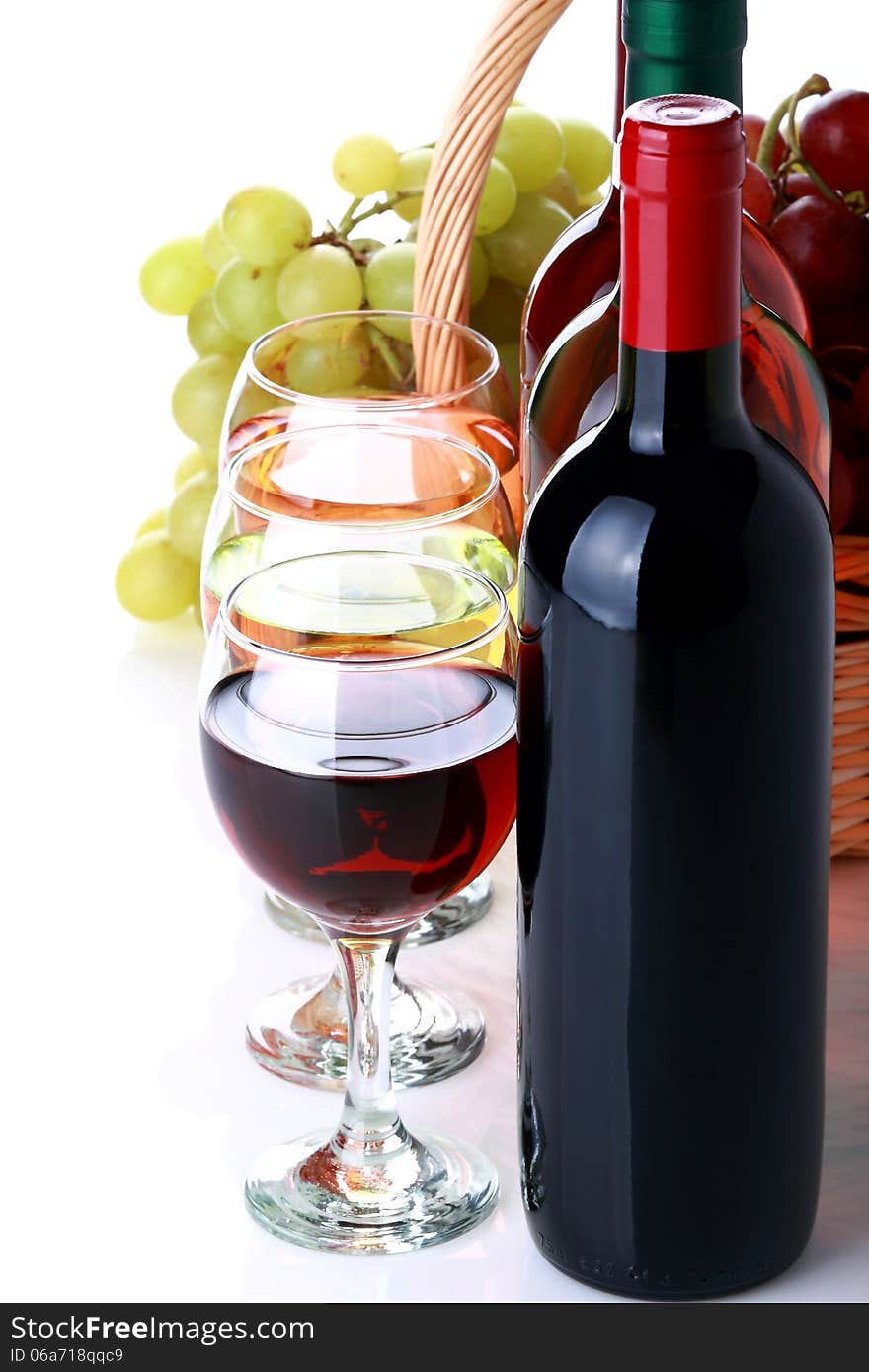 Bottles of wine with basket full of grapes on white background. Bottles of wine with basket full of grapes on white background