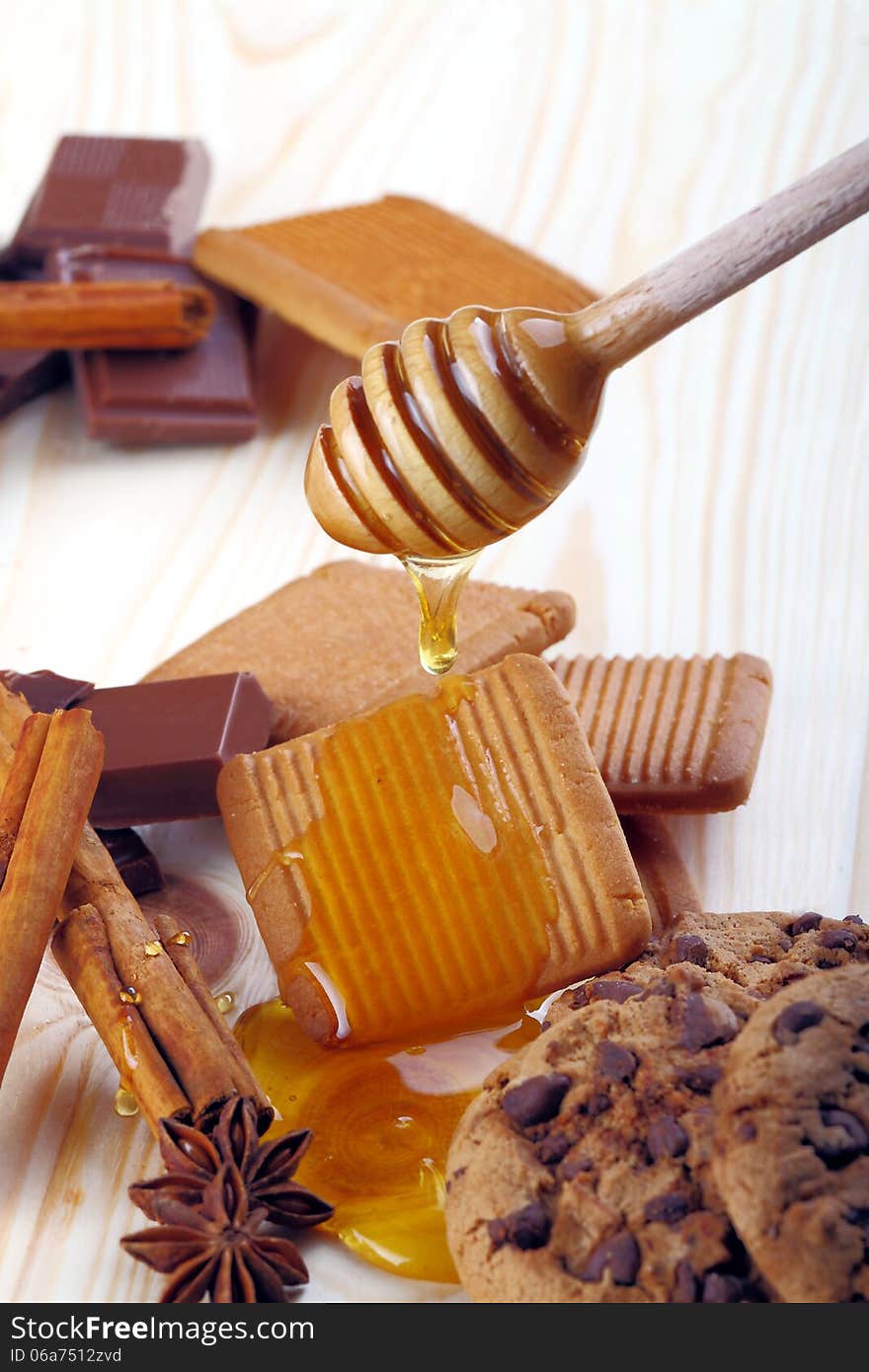 Teaspoon honey by biscuit on the background of fir wood. Teaspoon honey by biscuit on the background of fir wood