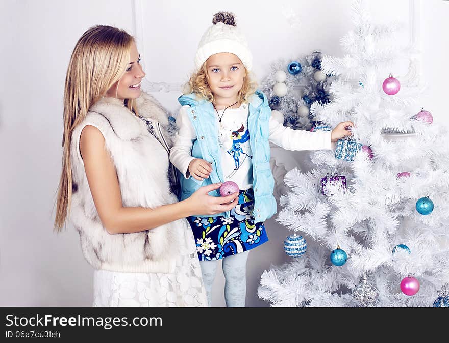 Little girl and her mother decorate Christmas tree. Little girl and her mother decorate Christmas tree