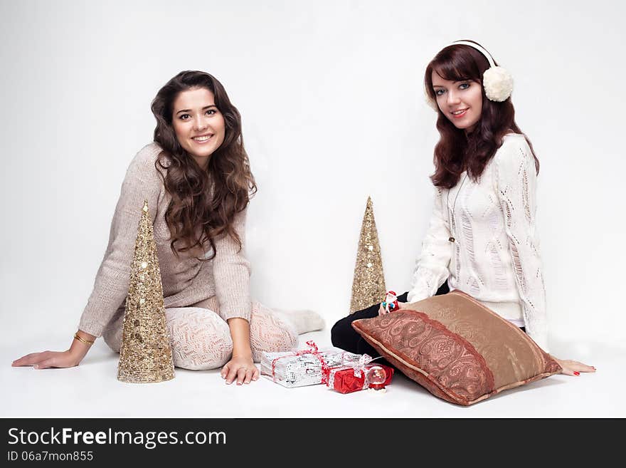 Happy girls sitting in christmas house on white background