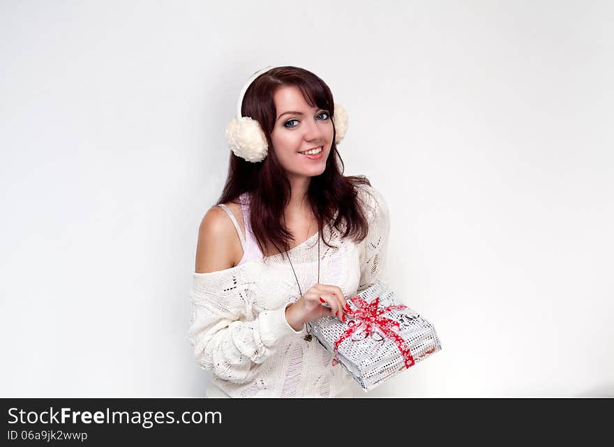 Smiling girl opening a present on white background