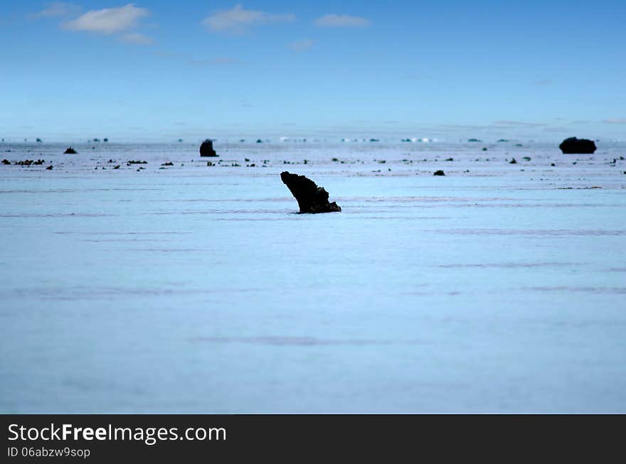 Landscape view of black basalt volcanic rocks in Arutanga island in Aitutaki Lagoon Cook Islands. Landscape view of black basalt volcanic rocks in Arutanga island in Aitutaki Lagoon Cook Islands.