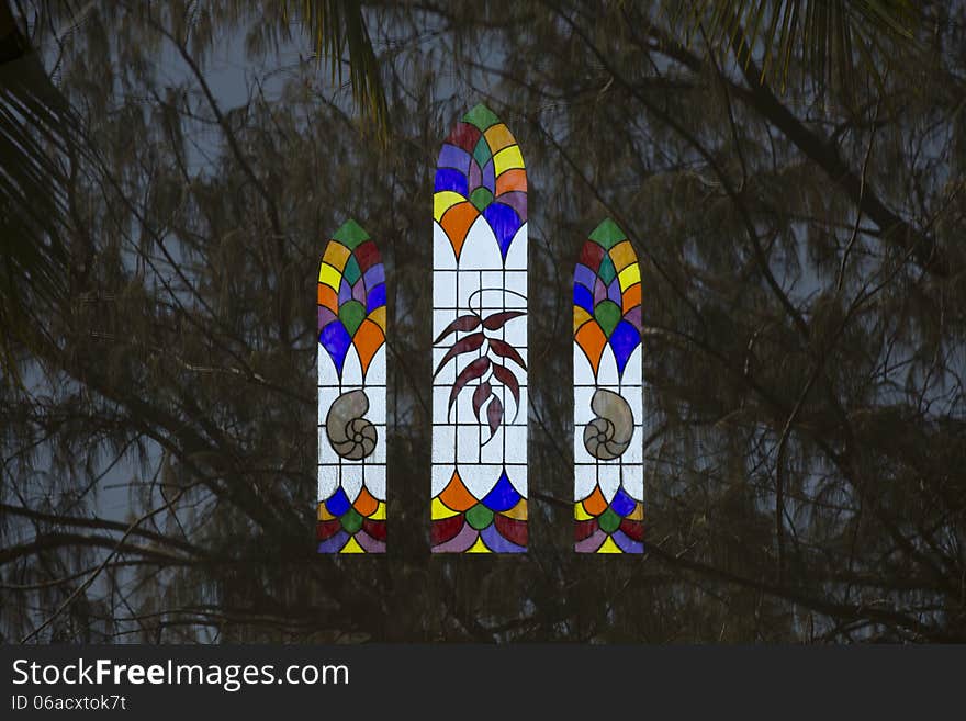 Stained glass window reflected against background of Casuarina trees. Stained glass window reflected against background of Casuarina trees