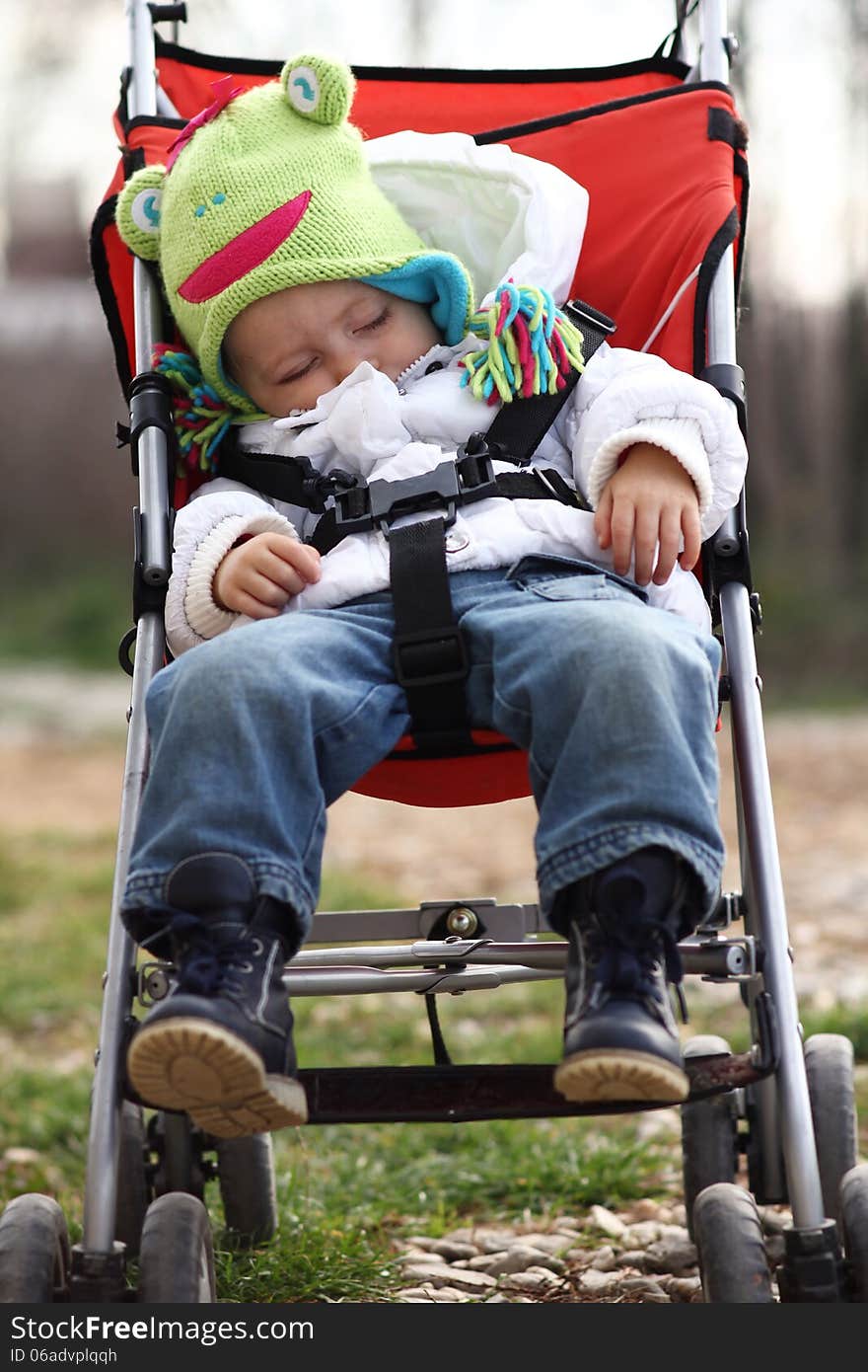 Cute baby girl heavy dressed sleeping in the pram. Cute baby girl heavy dressed sleeping in the pram