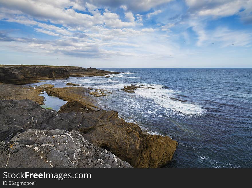 Ocean's waves hitting the stony shoreline on Hook Head Peninsula. Ocean's waves hitting the stony shoreline on Hook Head Peninsula