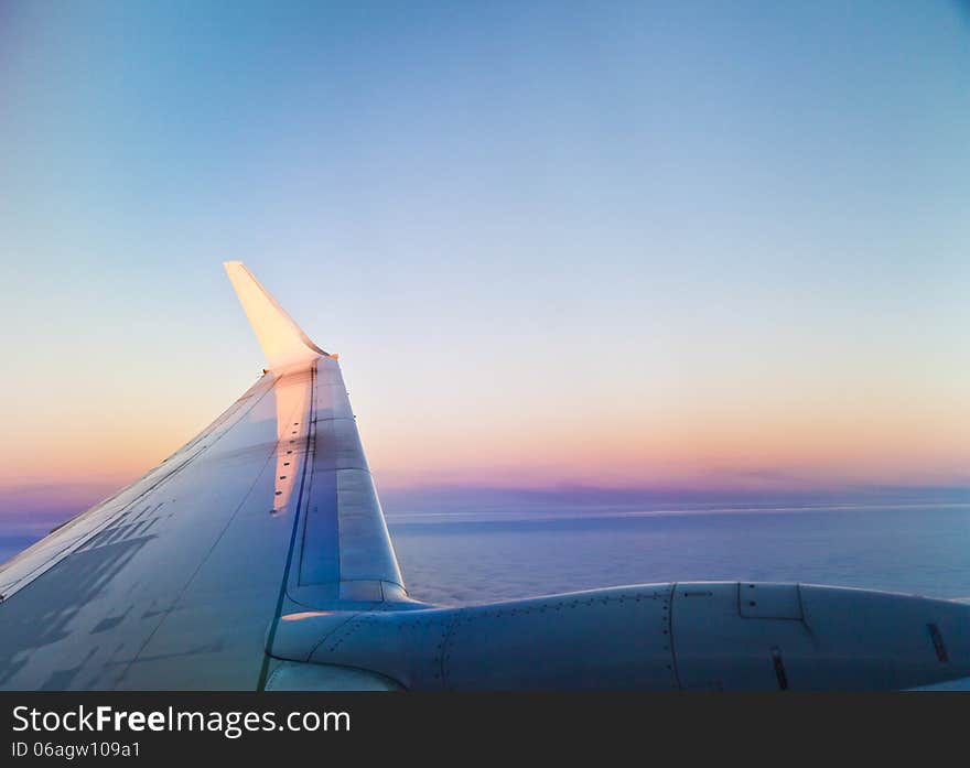 Plane wing against the sunset evening sky