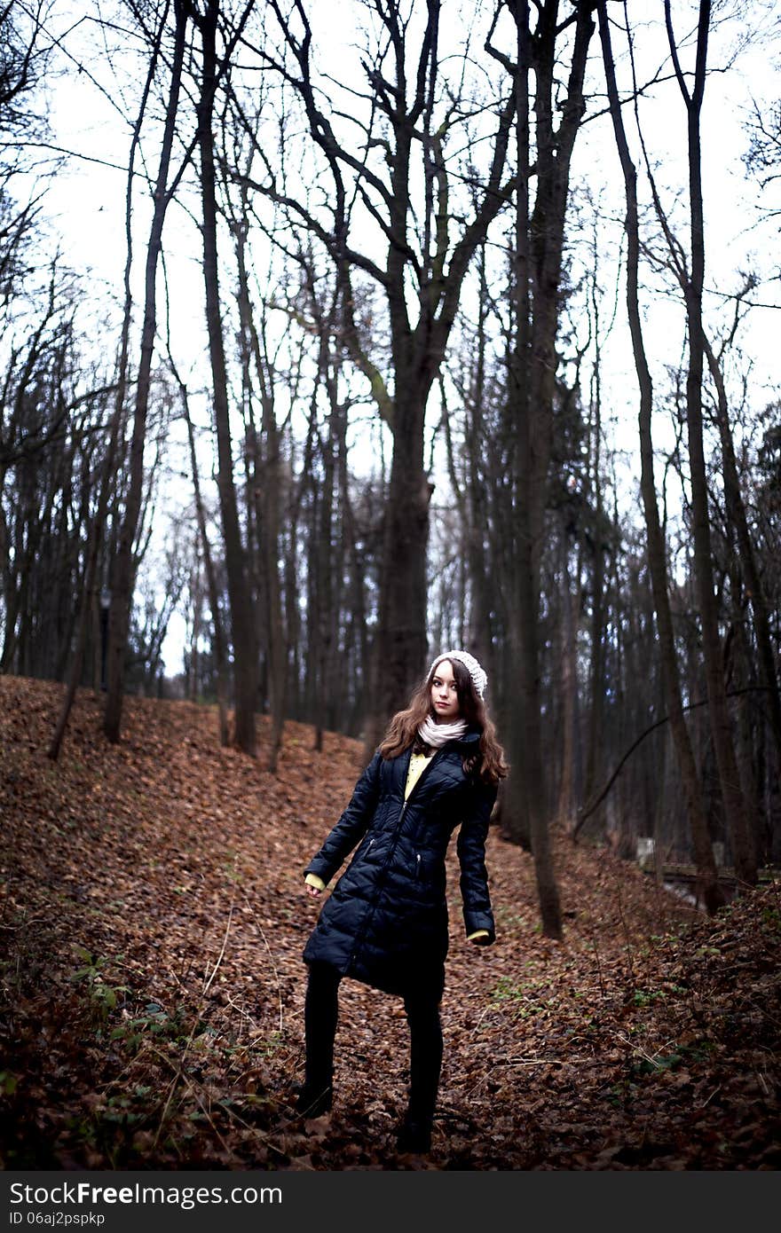 Woman in dark cold forest background