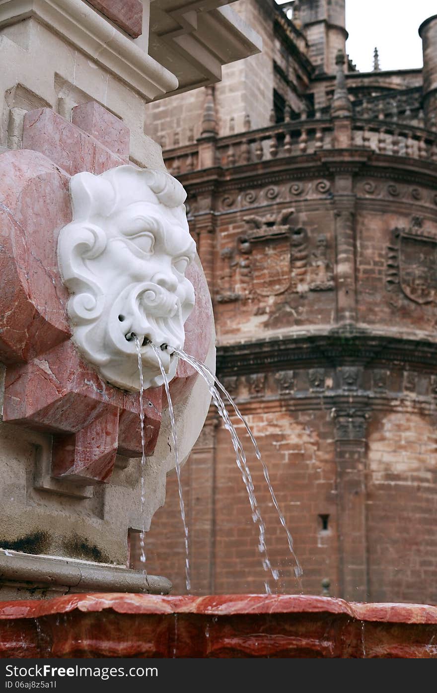 Ancient fountain against La Giralda Cathedral. Seville, Spain