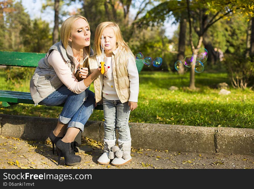 Mother And Her Little Kid With Soap Bubbles