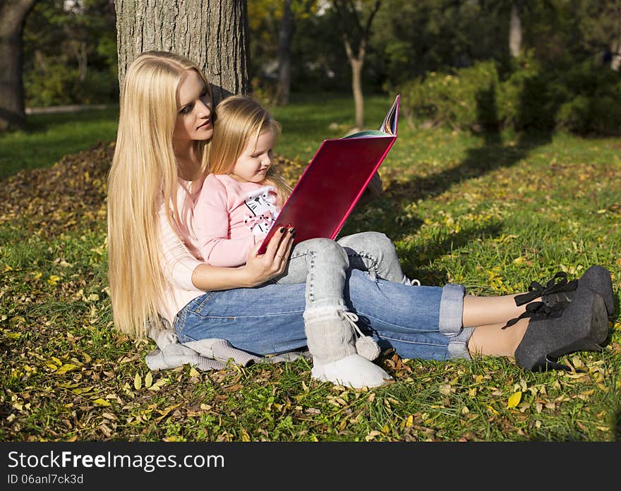 Mother And Her Little Girl Reading Book