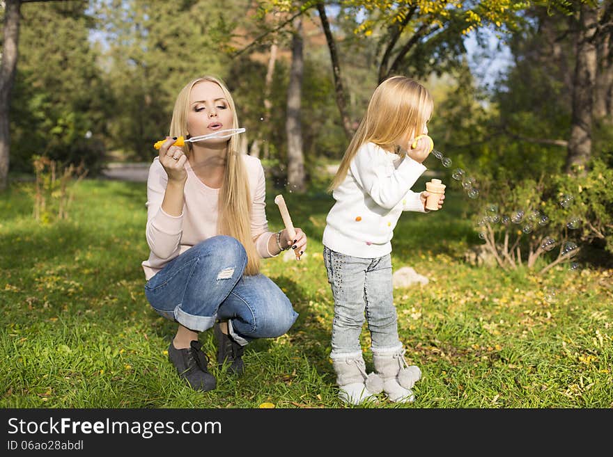 Mother and her little kid with soap bubbles