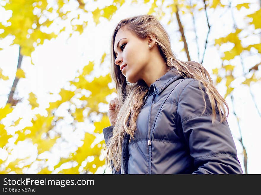 Gorgeous young woman on yellow autumn leaves background