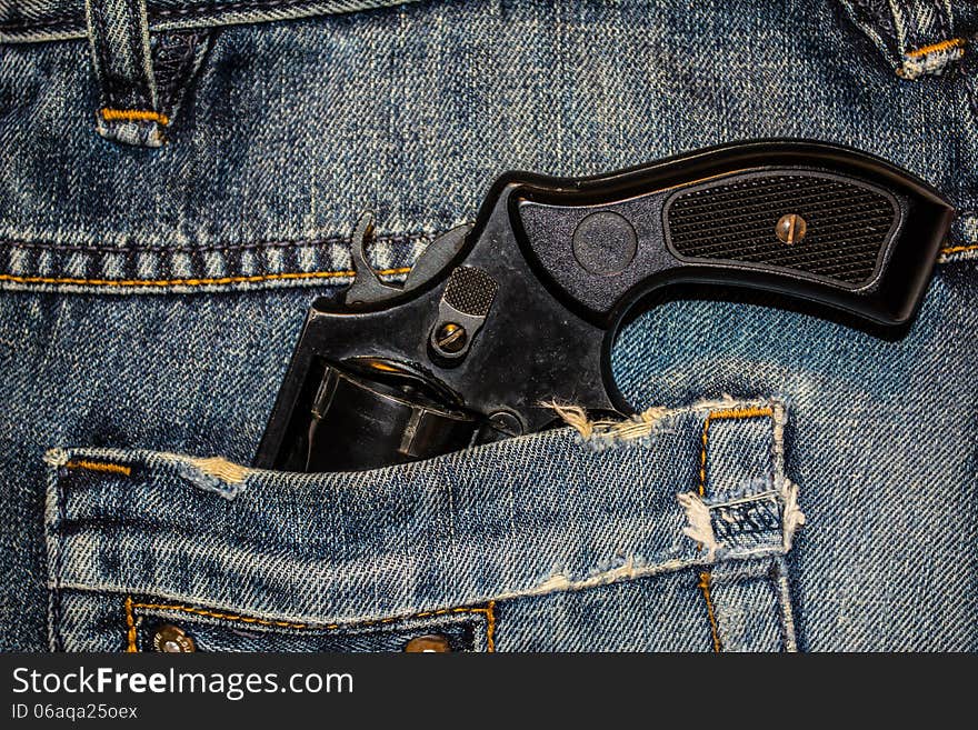 Background, texture, jeans and a revolver in his pocket