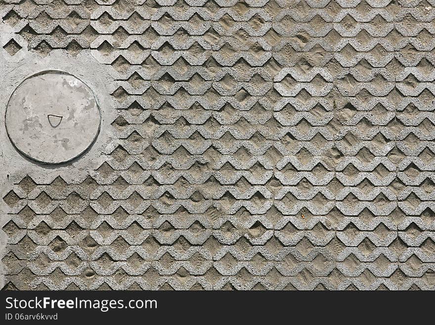 The fragment of a pavement footpath Paving stone with holes and manhole