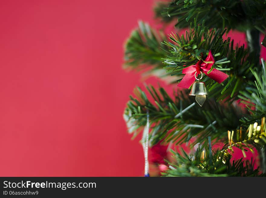 Small Bell On Christmas Tree On Red Background