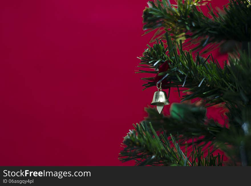 Small Bell On Christmas Tree On Red Background