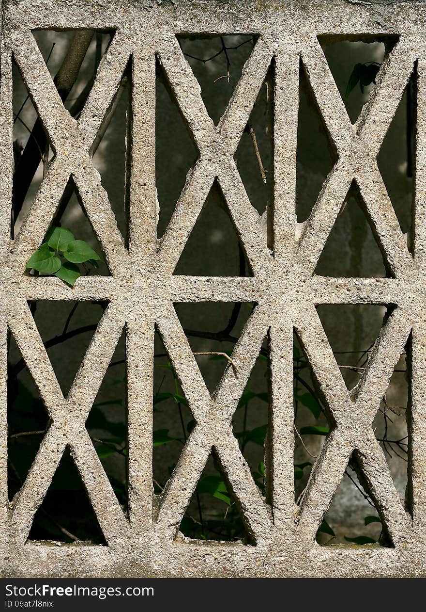 The fragment of a pavement footpath Paving stone with holes guardrail the stone fence