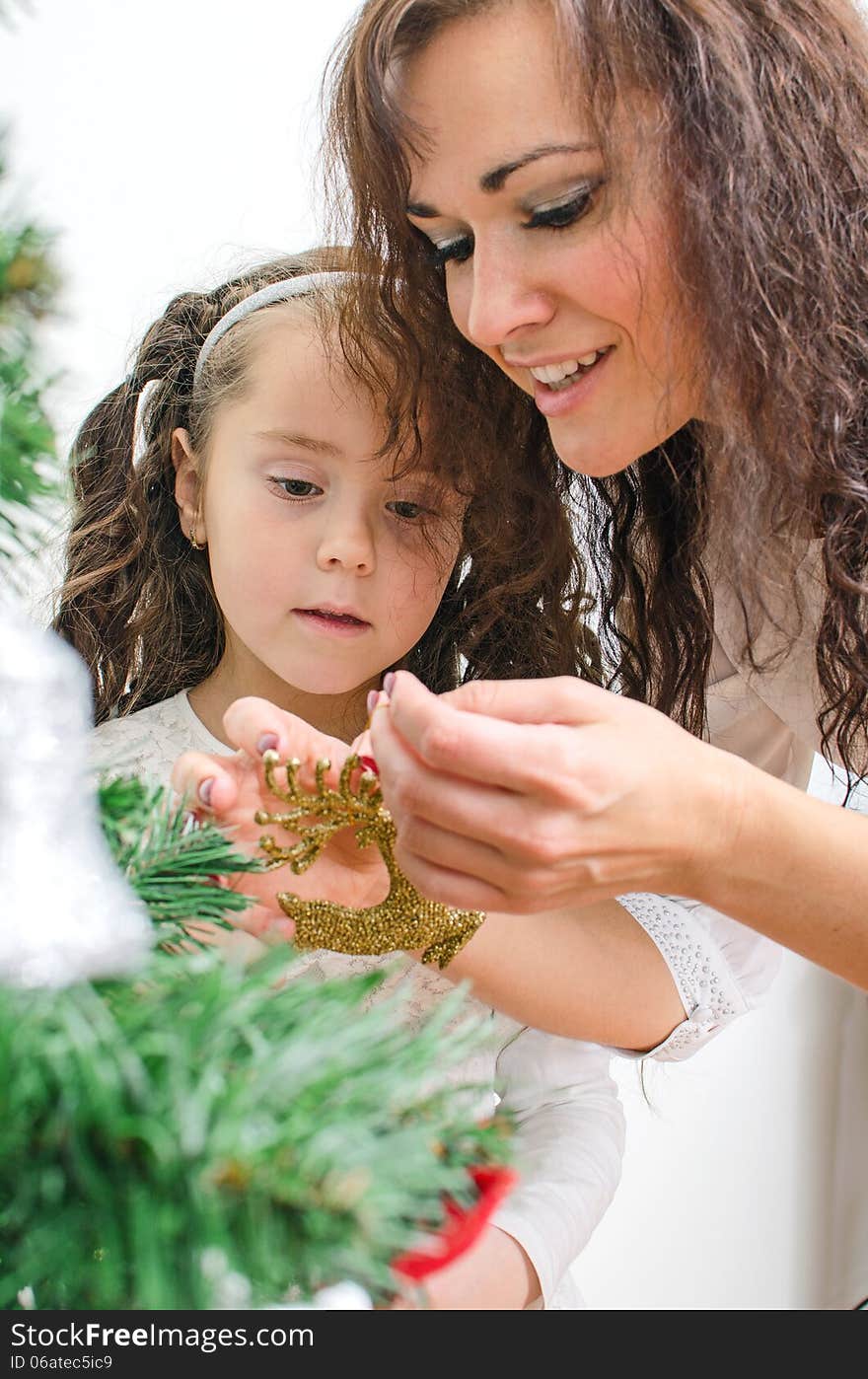 Woman and her daughter decorating the Christmas tree