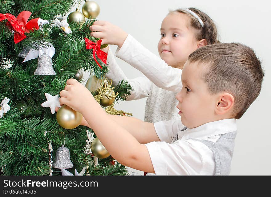 Children decorating Christmas tree with balls. Children decorating Christmas tree with balls.