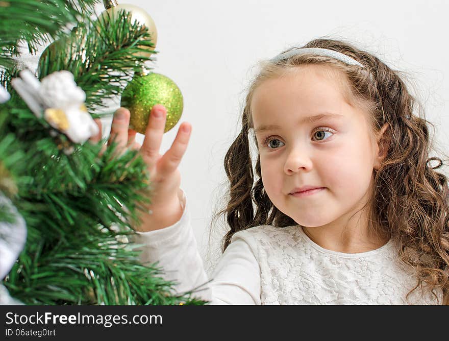 Little girl decorates the Christmas tree. Little girl decorates the Christmas tree