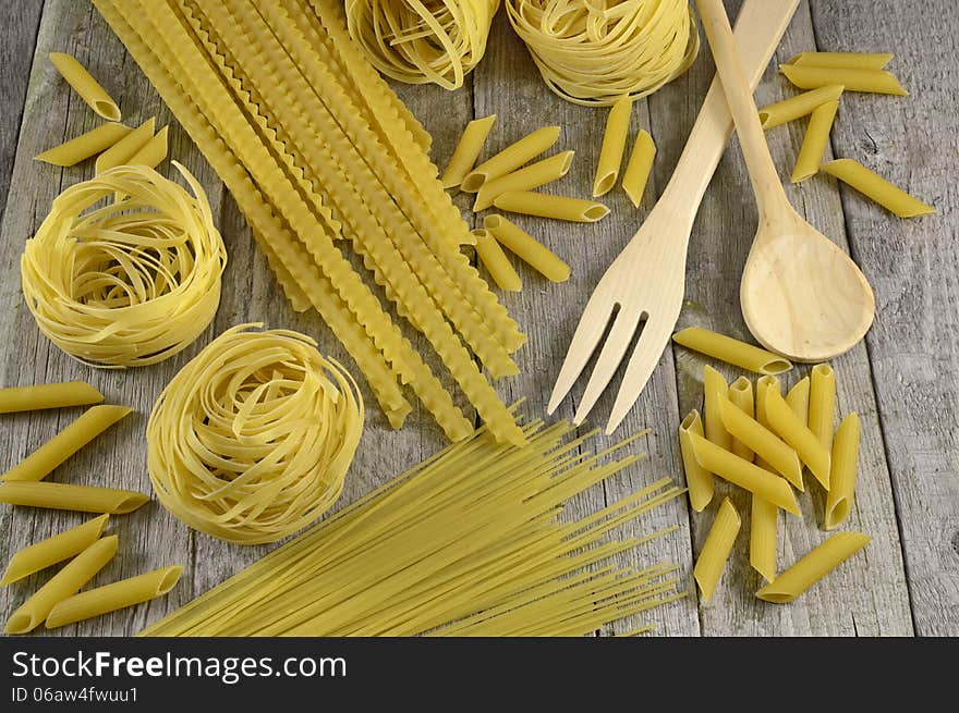 Vintage macaroni background on wood with spoon and fork