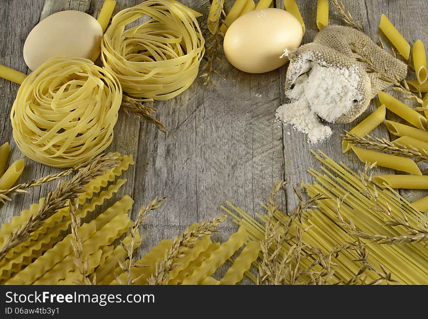 Macaroni border with eggs and flour on wood. Macaroni border with eggs and flour on wood