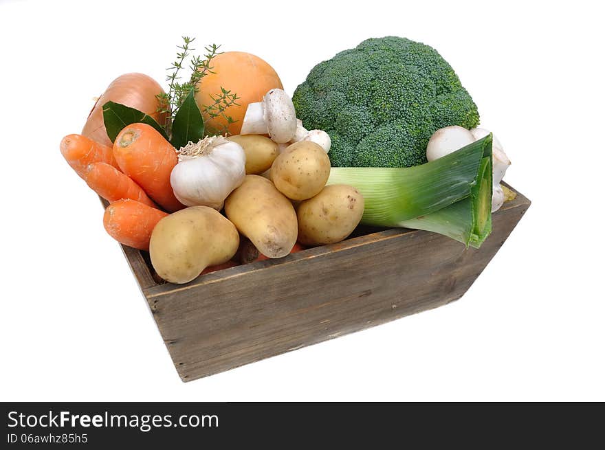 Several seasonal vegetables in a wooden basket on white background