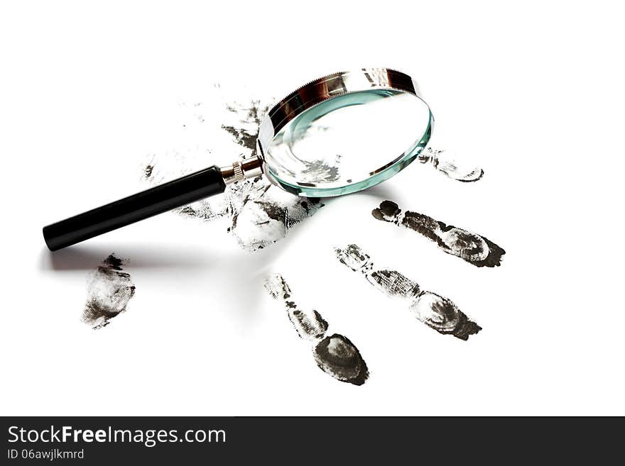 Crime concept. Black fingerprints and magnifying glass on white background