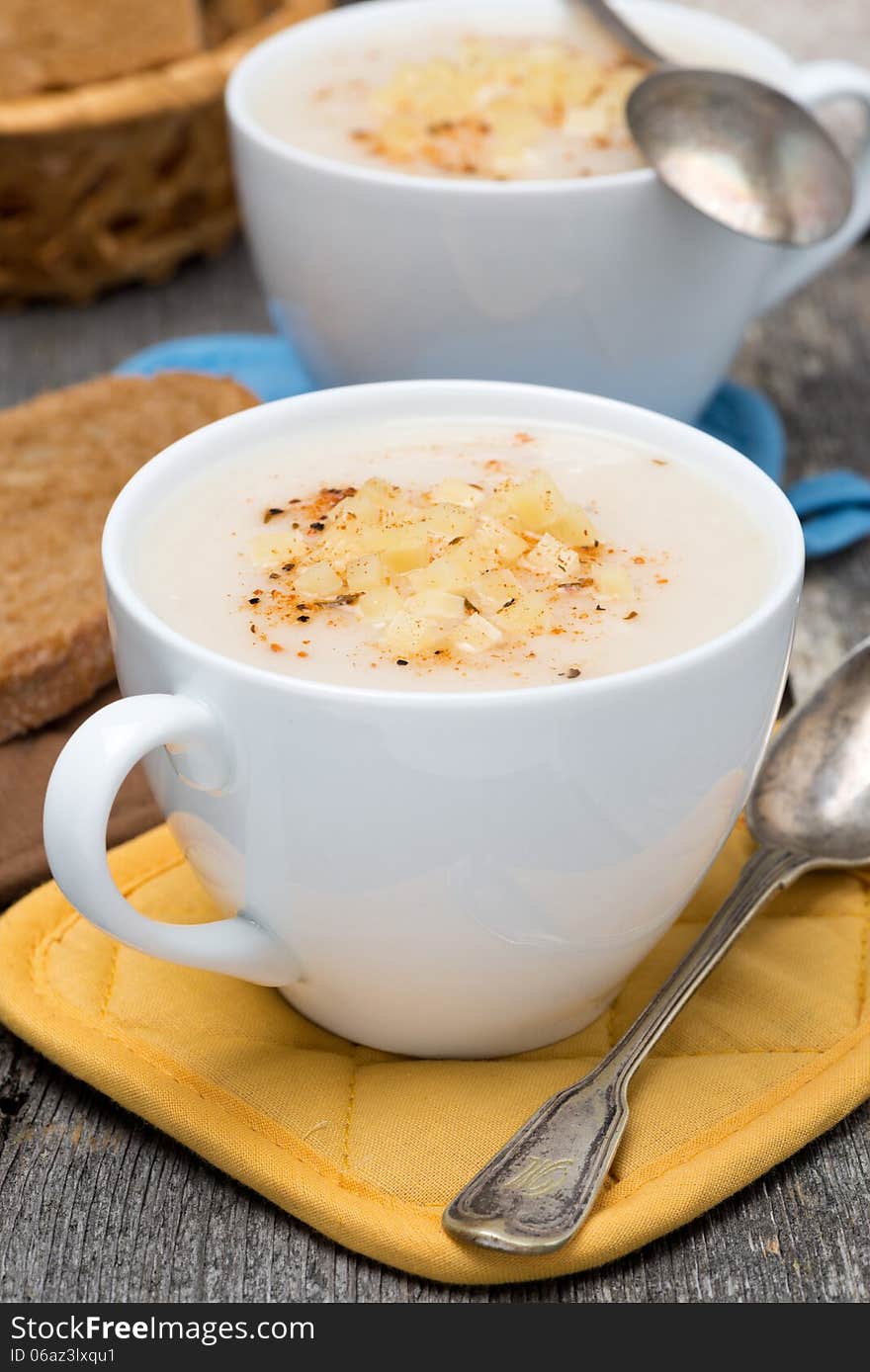 Cream soup of cauliflower with cheese in a cups, vertical, close-up