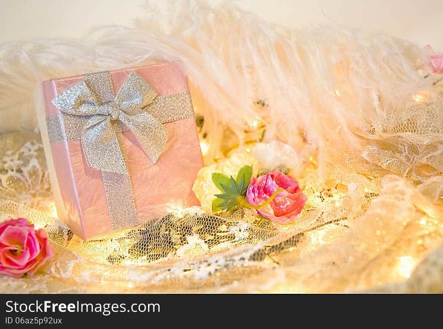 Pink gift box with roses and white feather background. Pink gift box with roses and white feather background