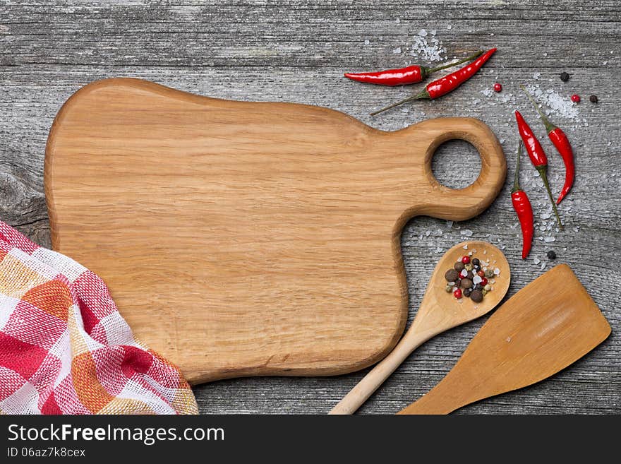 Figured wooden cutting board, spoon, spatula and spices