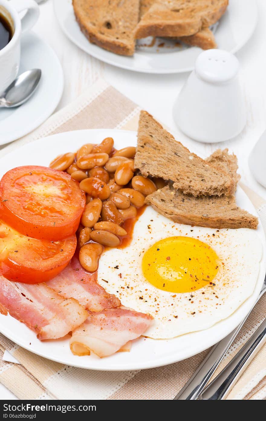 Traditional English breakfast with fried eggs, bacon and beans