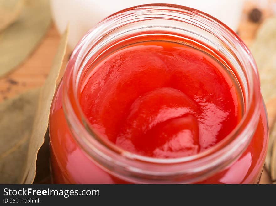 Tomato ketchup in a small glass jar close-up