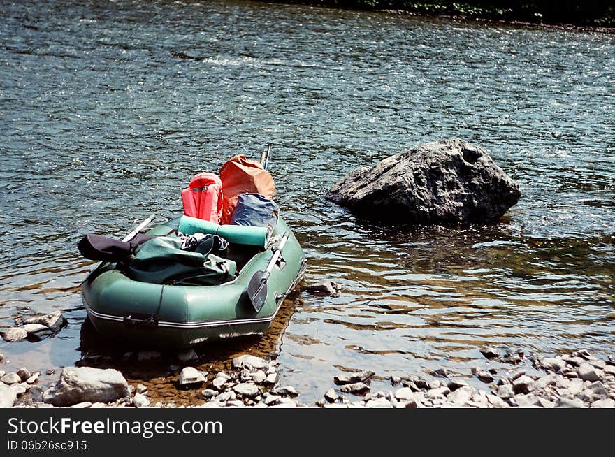 The rubber boat on water near a big stone, summer sunny day. The rubber boat on water near a big stone, summer sunny day