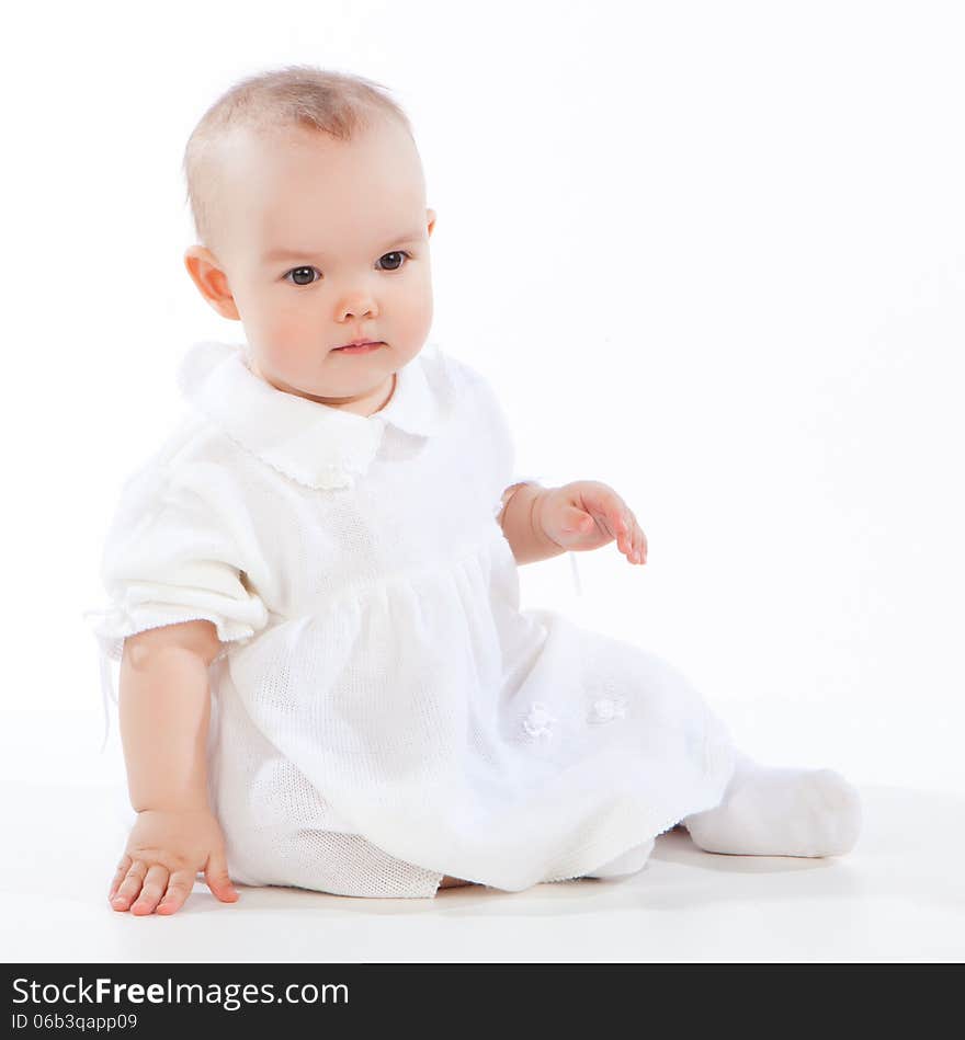 Little baby girl sitting on the floor, isolated on white