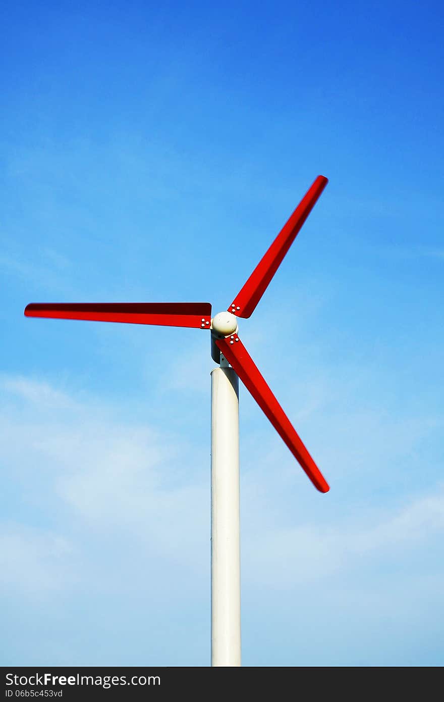 Red wind turbine working with blue sky