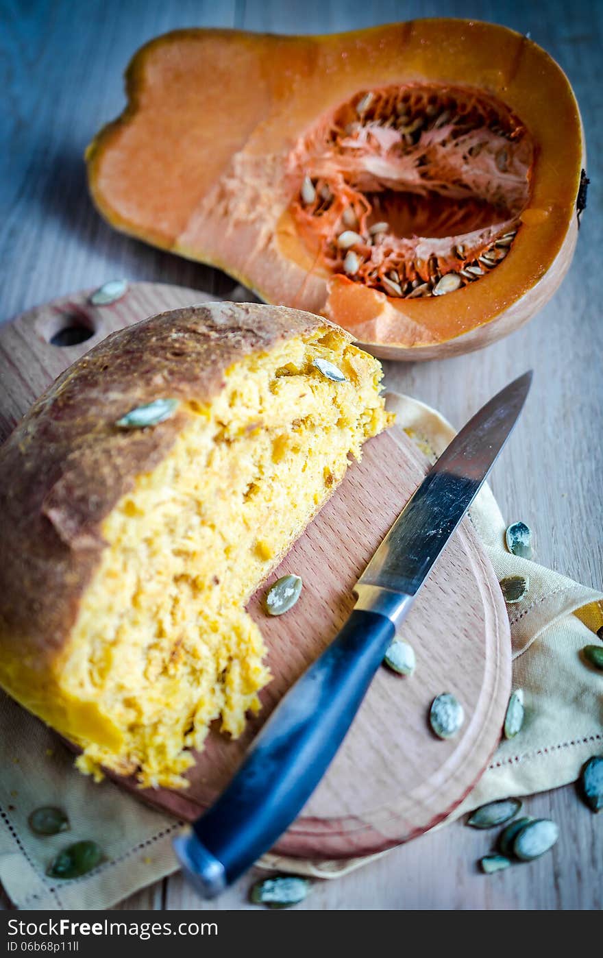 Loaf of pumpkin bread with pumpkin on background