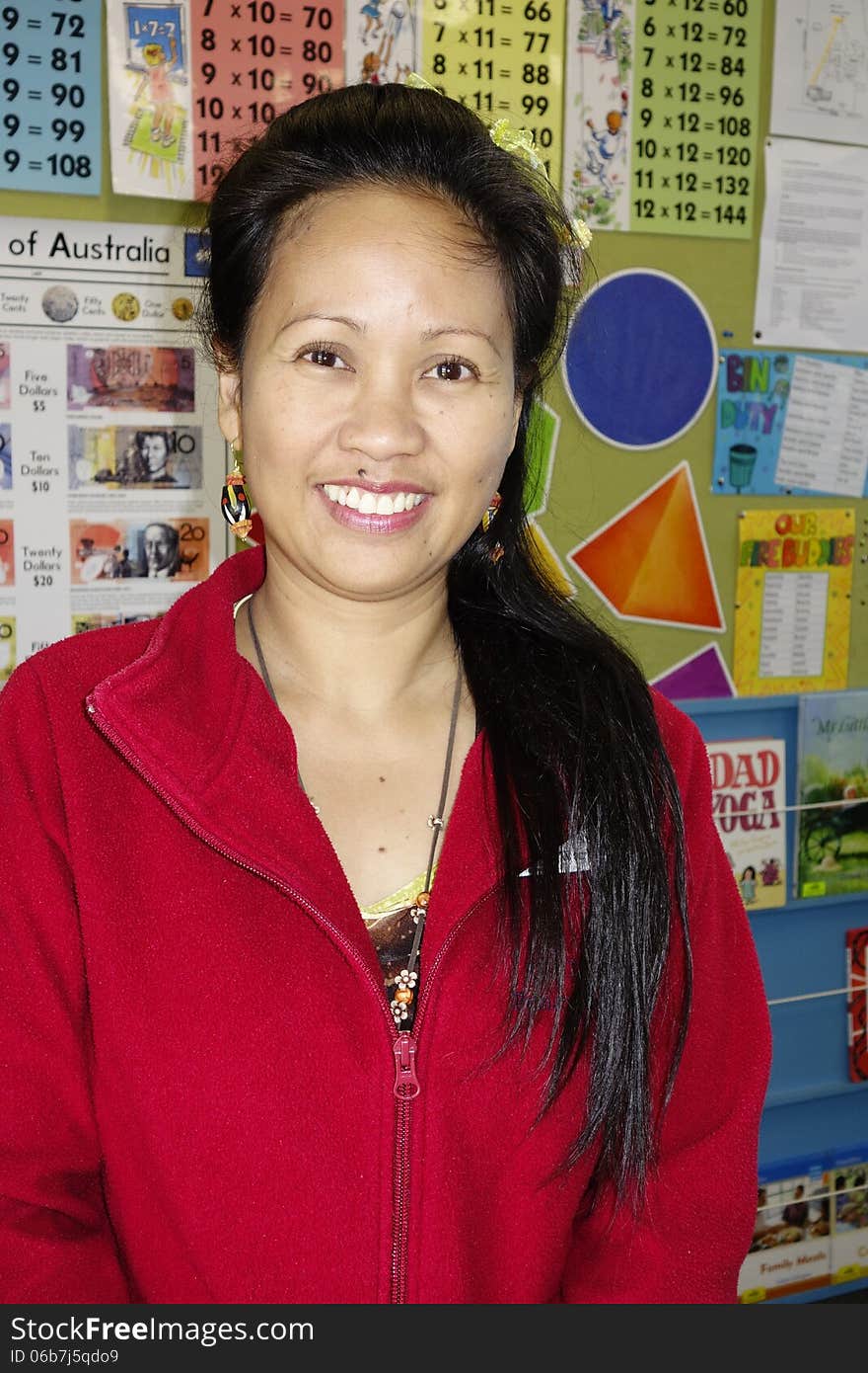 A proud primary school teacher from the Phillipines smiles happily in her classroom. A proud primary school teacher from the Phillipines smiles happily in her classroom.