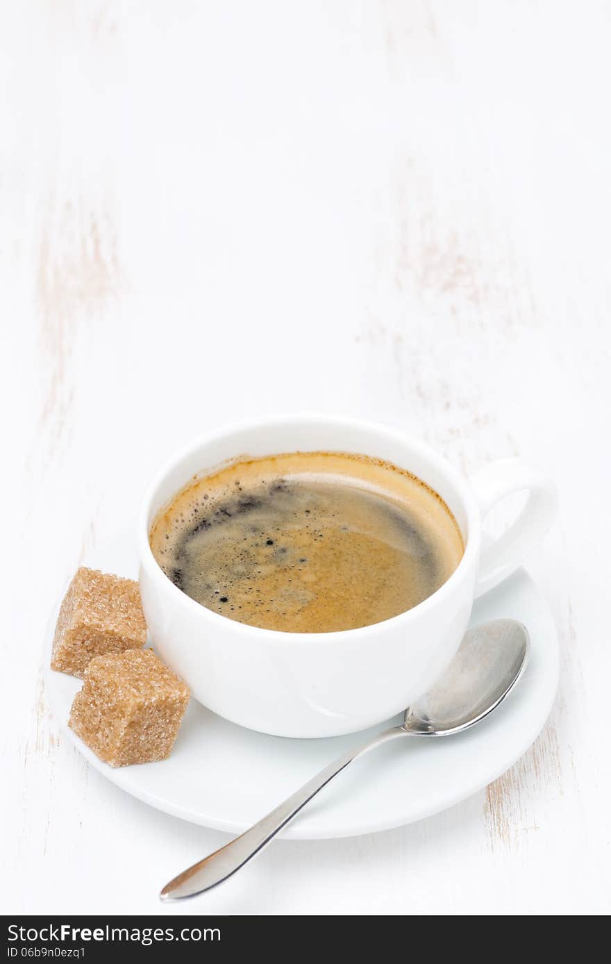 Cup of coffee with sugar on white wooden table and space for text, vertical. Cup of coffee with sugar on white wooden table and space for text, vertical