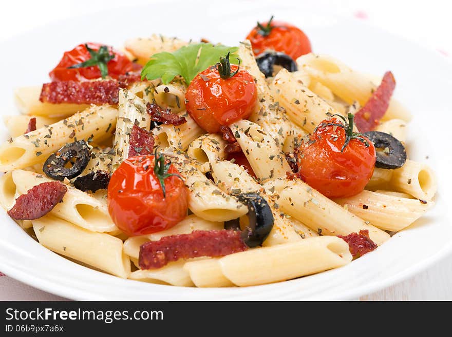 Pasta with sausage, tomatoes and olives, close-up